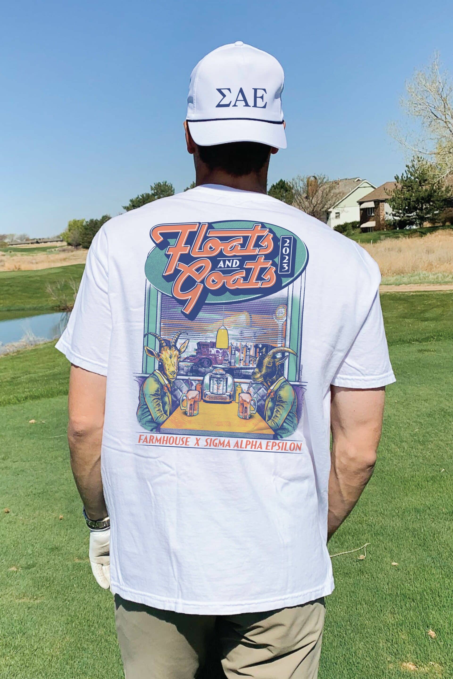 back of man wearing a hat and shirt on golf course